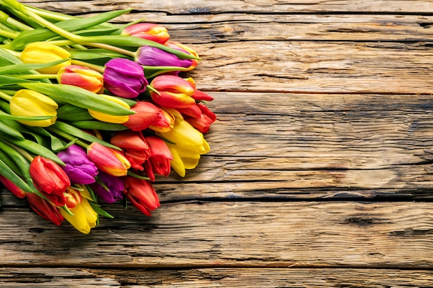 Uova di pasqua e tulipani sulle plance di legno