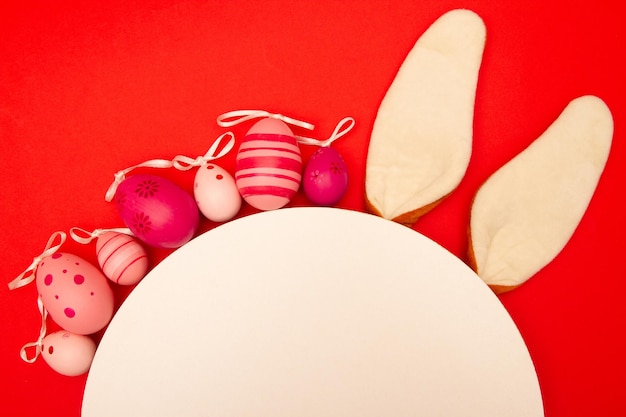 Easter eggs white circle and bunny ears decorate a red background