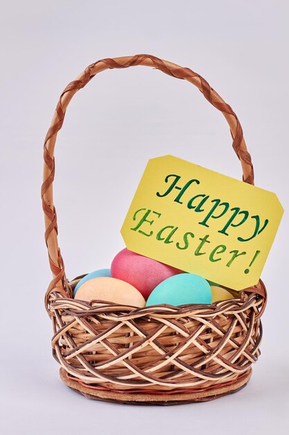 Easter Eggs in wicker basket Happy Easter greeting card