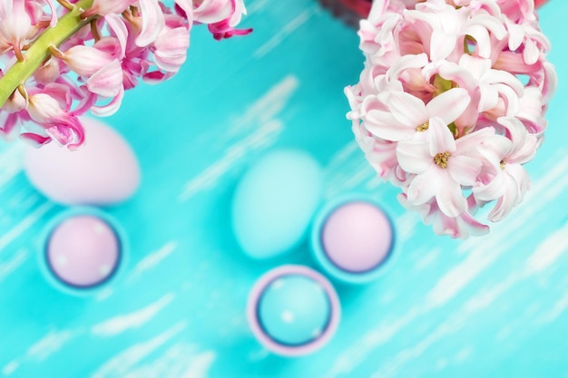 Easter eggs and willow branches on blue wooden background top view