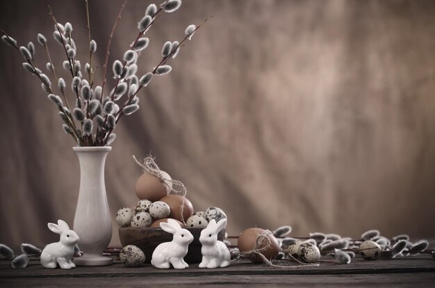 Easter eggs and willow branches on brown background