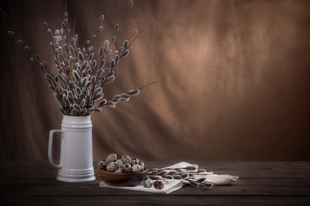 Easter eggs and willow branches on brown background