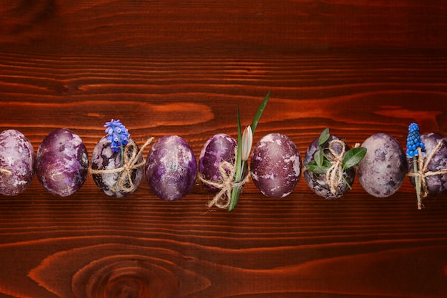 Photo easter eggs with spring flowers on a wooden table