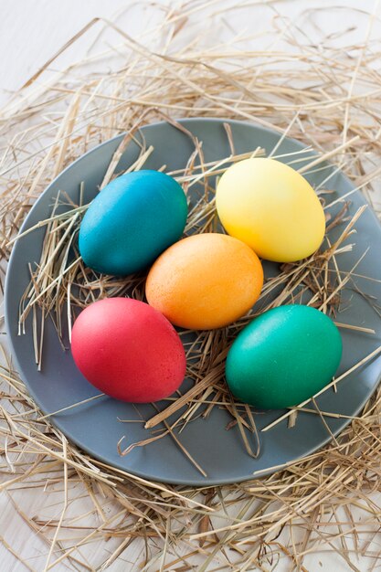 Easter eggs with straw on a plate