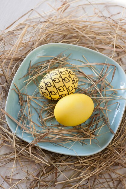 Easter eggs with straw on a plate