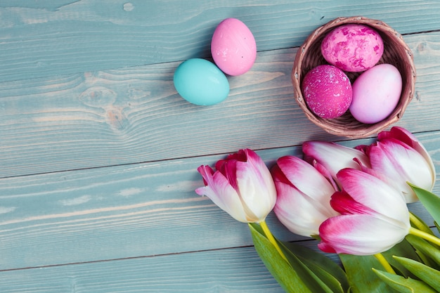 Easter eggs with tulips on blue wooden 