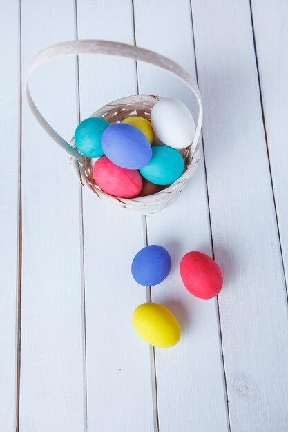 Easter eggs on wooden background  in the basket. 
View from above