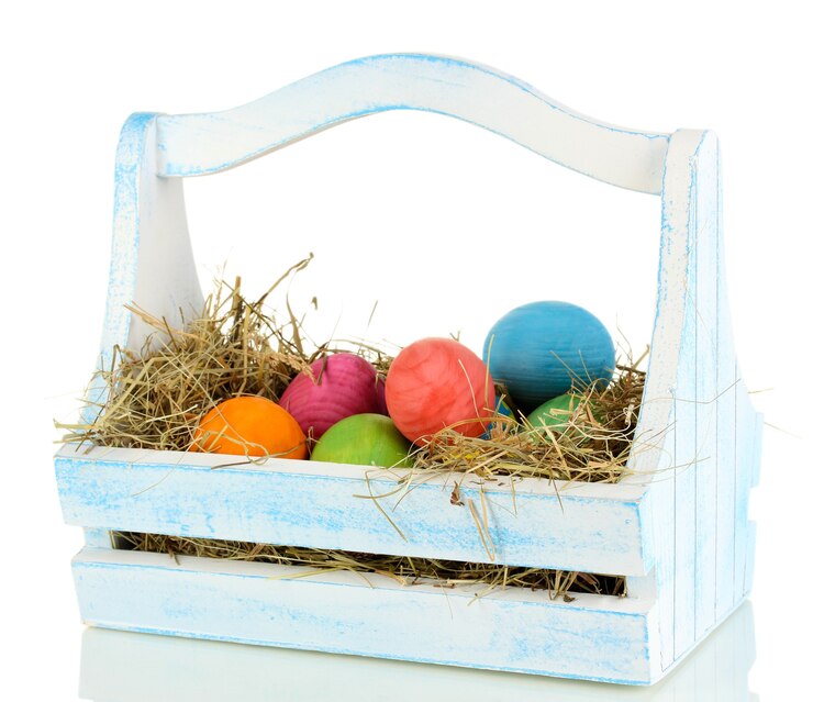 Photo easter eggs in wooden basket isolated on white