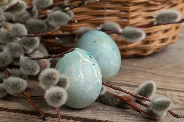 Foto uova di pasqua su una tavola di legno con ramoscelli di salice