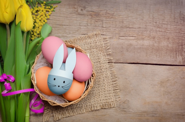 Photo easter eggs and yellow tulips on wooden background