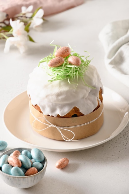 부활절 축제 케이크와 흰색 테이블에 다채로운 계란 수직을 닫습니다