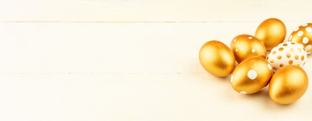 Easter festive decoration.Close up of easter eggs colored with golden paint on wooden surface. Various dotted designs. Banner