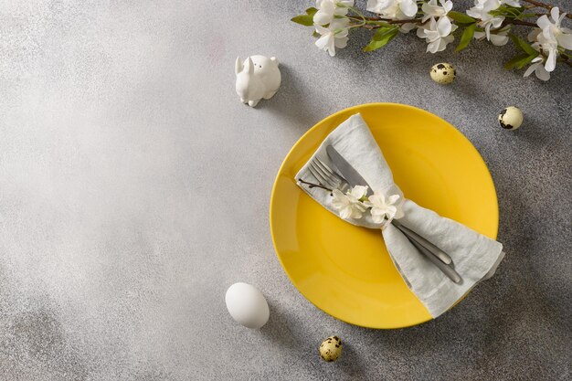 春の装飾とカラフルな卵とイースターのお祝いのテーブルの設定