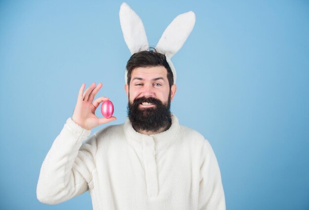 Easter food Easter egg is symbol of new life and resurrection Hipster wearing long rabbit ears with Easter egg Bearded man in Easter rabbit costume holding paschal egg Coloring eggs copy space