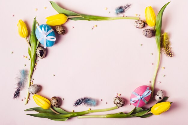 Easter Frame of beautiful yellow tulips, decorated eggs and beads. Holiday mock up