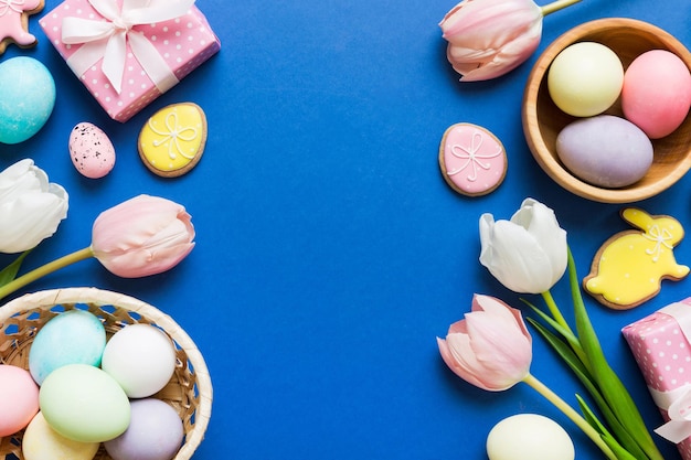 Foto cornice di pasqua con scatola regalo di uova e tulipano su uno sfondo colorato il concetto minimo vista superiore composizione di buona pasqua carta con uno spazio di copia del luogo per il testo