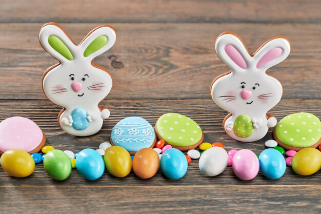 Photo easter ginger cookies and candies on wooden table.