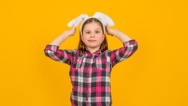 Foto ragazza di pasqua in orecchie da coniglio su sfondo giallo