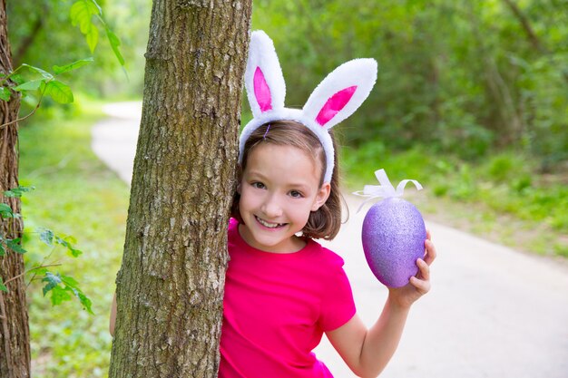 Easter girl with big purple egg and funny bunny ears