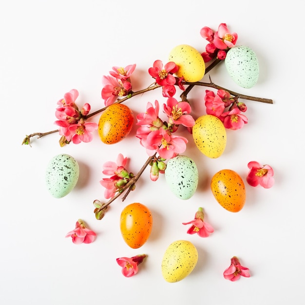 Foto easter greeting card achtergrond met japanse quince bloemen en eieren holiday compositie op witte achtergrond lente arrangement en ontwerp element vlakke lay top view