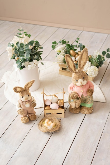 Easter hay bunnies mother and son in an Easter decorative composition eggs flowers