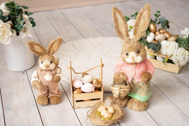 Easter hay bunnies mother and son in an Easter decorative composition eggs flowers