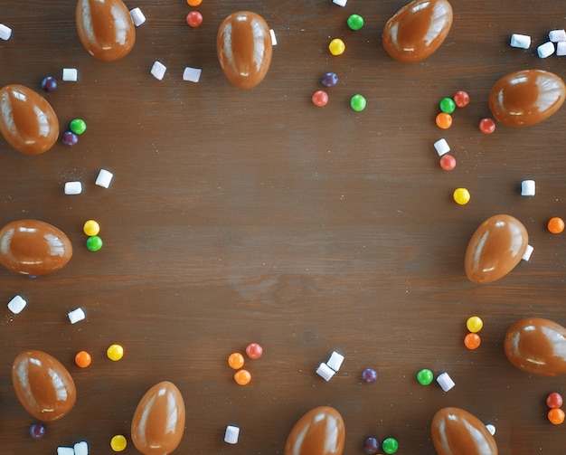 Easter holiday background Chocolate eggs and colorful sprinkle Top view