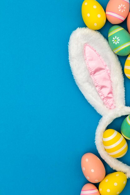 Easter holiday background with bunny ears and easter eggs on a blue background