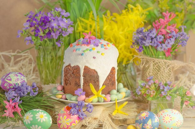 Easter holiday background with eggs and flowers Creative photo with easter eggs Easter cake and colored decorated Easter eggs