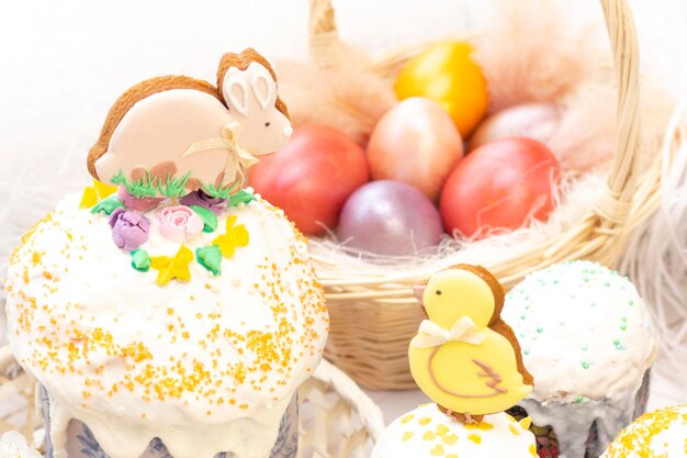 Easter holiday Colored eggs in a basket Easter gingerbread chicken and rabbit on the sandwich on a light background