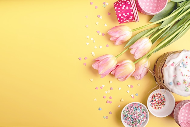 Easter holiday creative background with easter cake, tulips and decorations top view flat lay with copy space