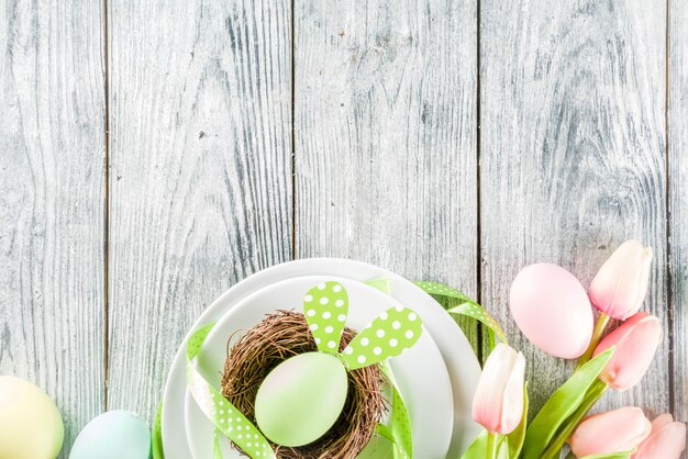 Easter holiday table setting with rabbits and eggs