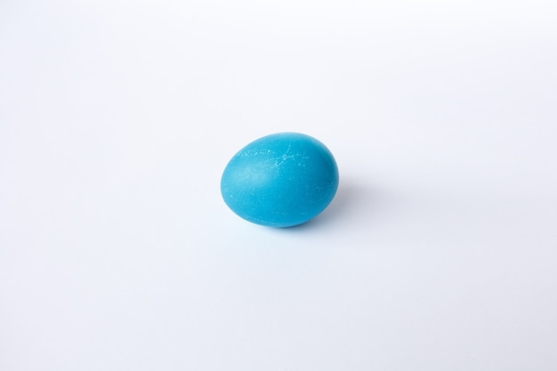 Пасха, праздники, традиции, стиль и концепция минимализма - синее пасхальное яйцо на белом фоне