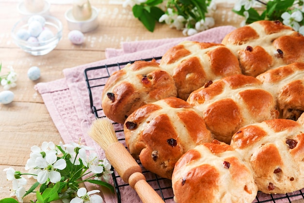 이스터 핫 크로스  (Easter hot cross buns) 전통적인 이스터 트리트 (traditional Easter treats)  (cross buns with raisins butter chocolate candy eggs with blooming cherry or apple flowers on rustic light wooden backgrounds) 이스터 휴일 식사