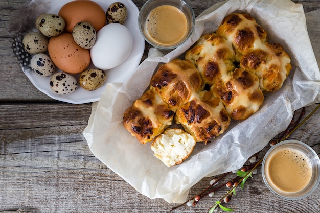 Photo easter hot cross buns with eggs rustic wood background