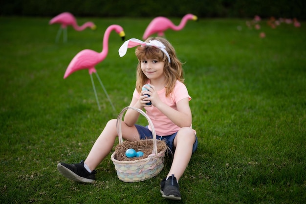 Easter kid in park child in bunny ears hold easter egg boy hunting easter egg