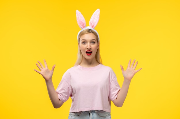 Easter lovely blonde adorable girl with pink bunny ears and red lipstick with open palms