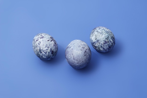 Easter marbled purple eggs on blue background