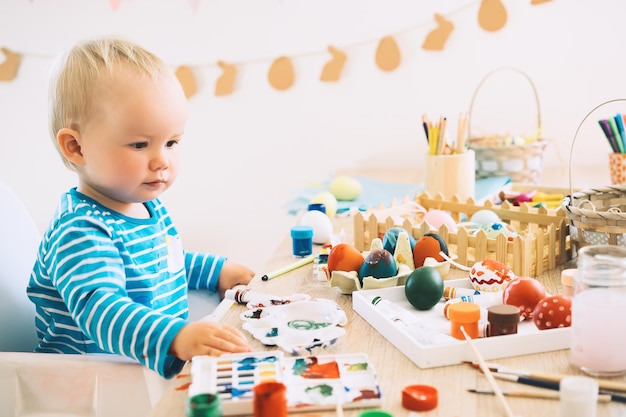 Easter morning Little children painting eggs Family preparing for Easter Paints felttip pens decorations for coloring eggs for holiday Creative background for preschool and kindergarten