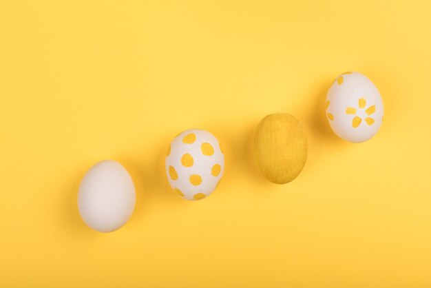 Easter painted eggs on yellow table, copy space