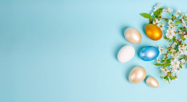 Easter painted mother-of-pearl eggs with cherry blossoms on blue