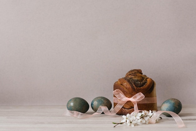 Easter or Palm Sunday Painted chicken eggs Blue eggs on a light wooden table An Easter cake tied