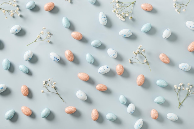 Easter pattern with sweets as chocolate eggs and gypsophila flowers