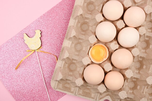 Easter pink. Egg on a wooden spoon. A tray of eggs on a white and pink background. eco tray with testicles. minimalistic trend, top view. Egg tray. Easter concept.