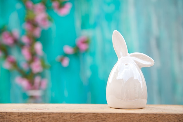 Easter rabbit on a background of a blossoming tree in spring.