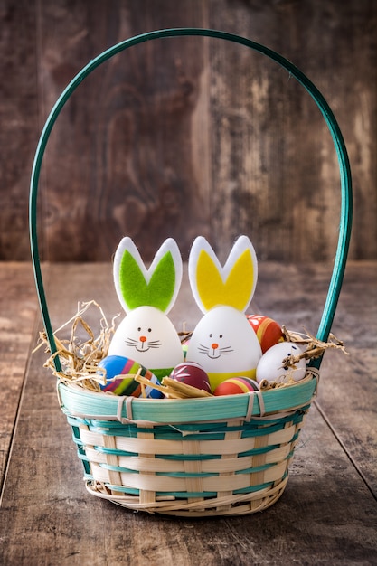 Easter rabbits and eggs in a basket on wooden table