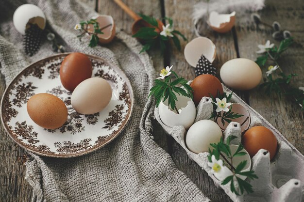 Easter rustic still life Natural easter eggs blooming spring flowers burlap spoon on rural wood