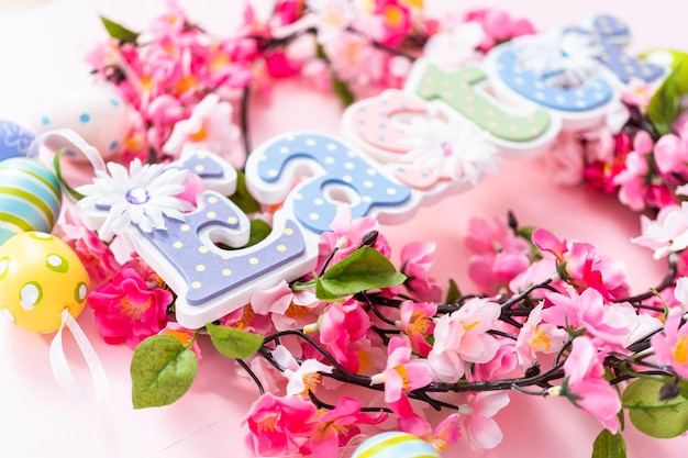 Easter sign with flower wreath on a pink backgraound.