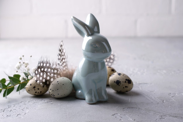 Easter spring decorative composition  with easter quail eggs and leaf sprigs of eucalyptus and ceramic bunny with place for text.