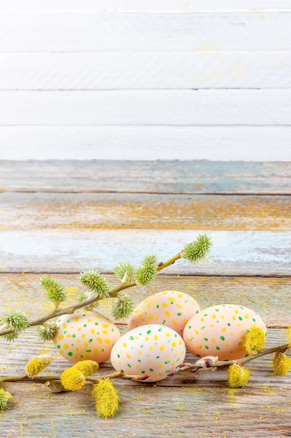 Easter spring still life of flowering willow branches and eggs on a retro wooden table on a white background